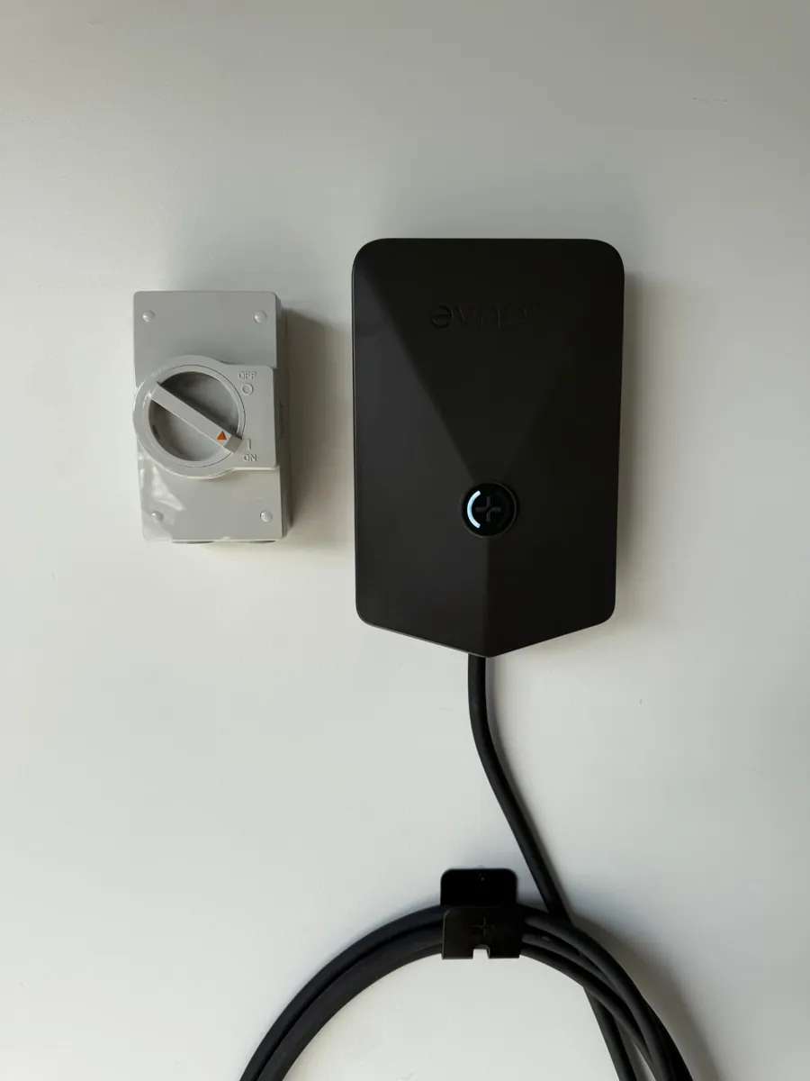 Evnex EV charger and isolator switch installed on a white wall