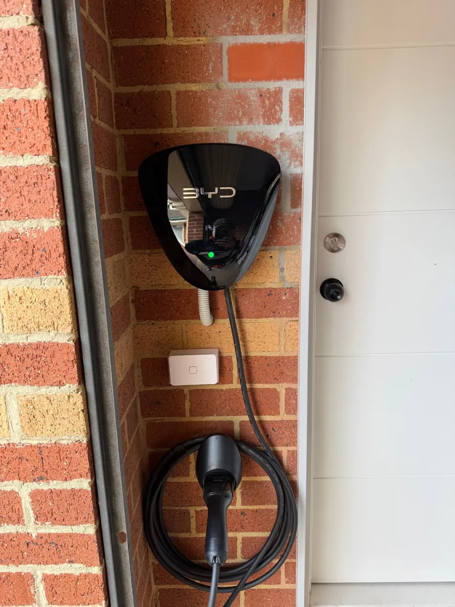 BYD home EV charger installed beside a garage entry door