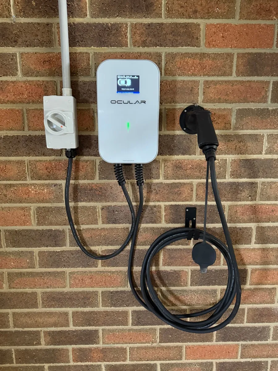 Ocular EV charger installed with isolator switch on a brick wall
