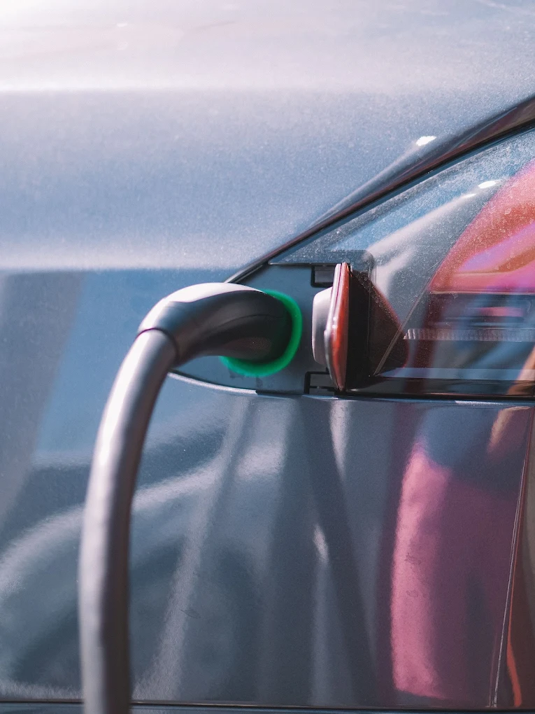 Close-up of an electric vehicle charging port with a cable connected